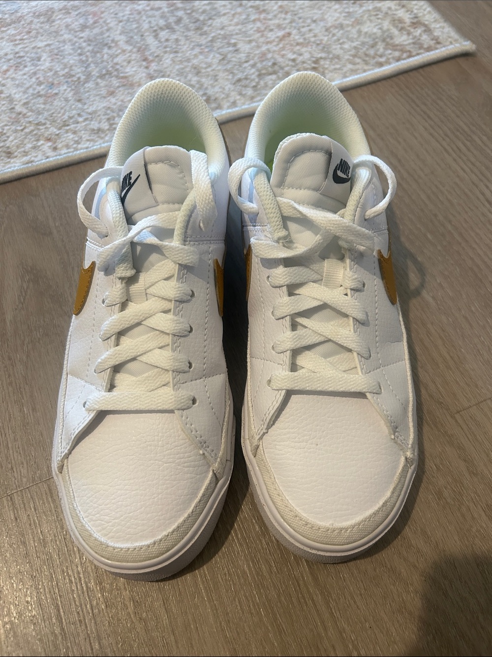 Nike Women’s White Sneakers with Gold Swoosh